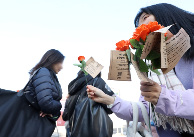 8 марта, в честь Международного женского дня, работники Корейской женской горячей линии дарят розы студенткам Женского университета Ихва в районе Содэмун-гу в Сеуле.
