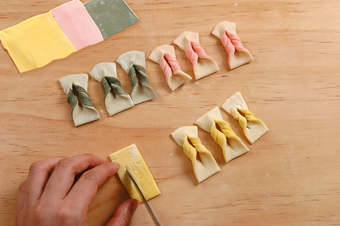 Cut the rolled dough into 2 cm-wide and 4 cm-long. Make three slits, insert one end into the center slit, then flip over.