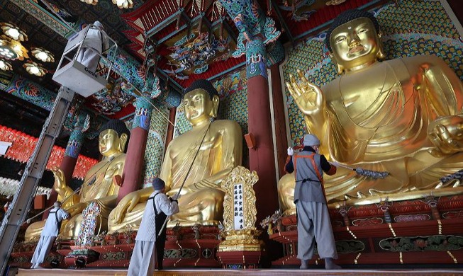 Монахи чистят статуи Будды