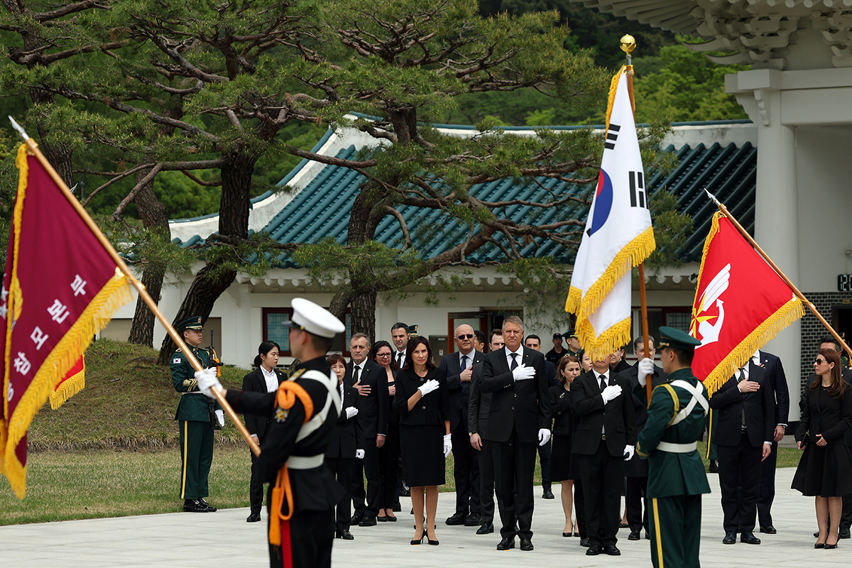 Президент Румынии Клаус Йоханнис вместе с первой леди Кармен Йоханнис, находящиеся с официальным визитом в Корее, 22 апреля приветствуют национальный флаг в Сеульском национальном кладбище, расположенном в районе Тончжак-гу в Сеуле.