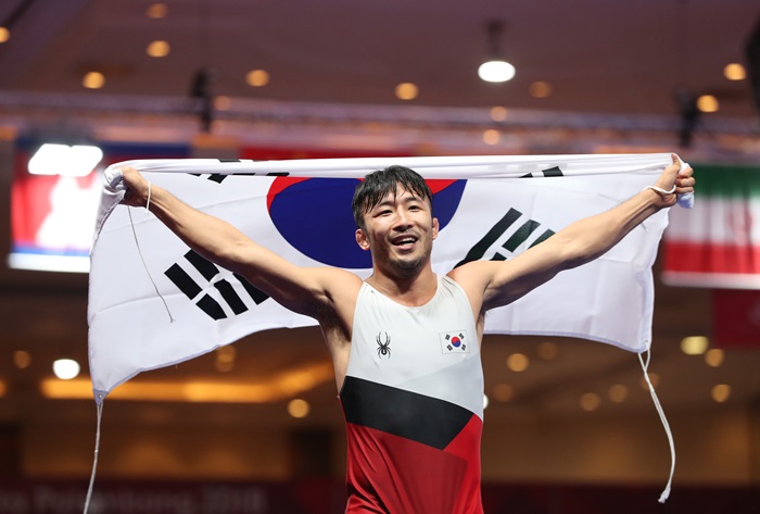 Корейский борец Рю Хан Су 21 августа демонстрировал национальный флаг Тхэгыкки после победы в финале греко-римской борьбы в весовой категории до 67 кг в рамках летних Азиатских игр 2018 года. / Фото: Ренхап
