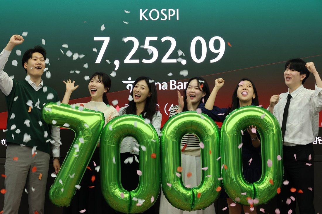  6 мая, после того как индекс KOSPI преодолел отметку 7000 пунктов, сотрудники в дилинговом зале головного отделения Hana Bank в округе Чун-гу в Сеуле проводят праздничную церемонию. / Фото: Рёнхап