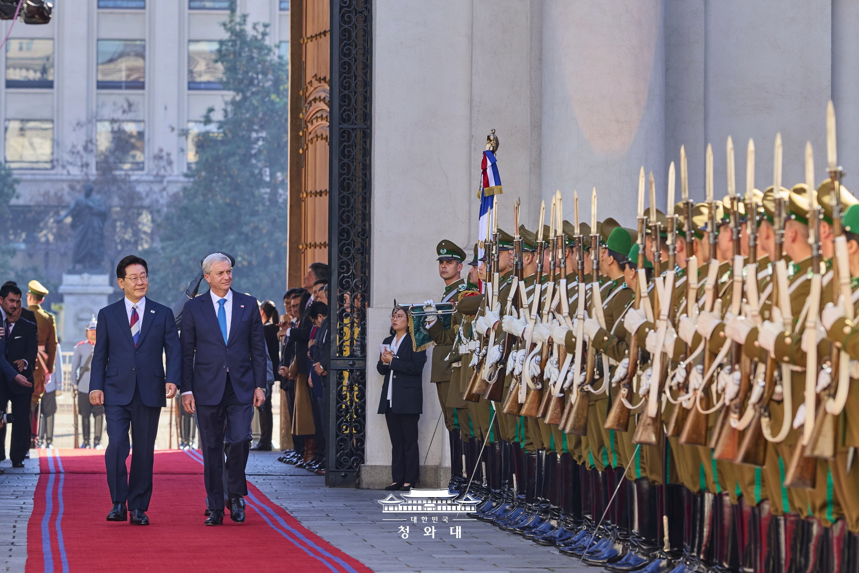 Президент РК Ли Чжэ Мён 30 июля (по местному времени) осматривает почетный караул вместе с президентом Чили Хосе Антонио Кастом на официальной церемонии приветствия, состоявшейся в Сантьяго. Это первый визит корейского лидера в Чили за последние 11 лет. В ходе саммита, состоявшегося в тот же день, лидеры двух стран договорились впервые за 10 лет возобновить работу Комиссии по свободной торговле, а также модернизировать соглашения о свободной торговле и поднять стратегическое партнерство на новый уровень. Для обеспечения стабильных поставок критически важных минералов стороны подписали пять меморандумов о взаимопонимании. Кроме того, было решено повысить уровень комитетов по сотрудничеству в области ресурсов до министерского и создать рабочий канал для оперативного взаимодействия. / Фото: Чхонвадэ 