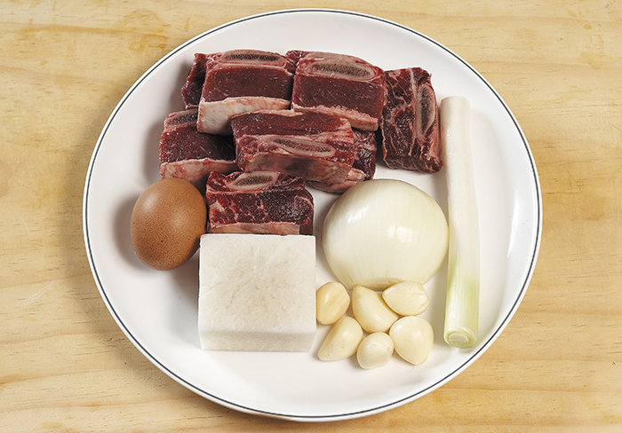 The ingredients of galbitang are beef ribs, radishes, green onions, garlic and eggs.
