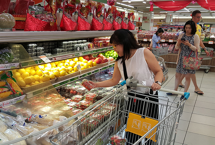 A shopper inspects a packet of Korean Maehyang strawberries at a store in Singapore.