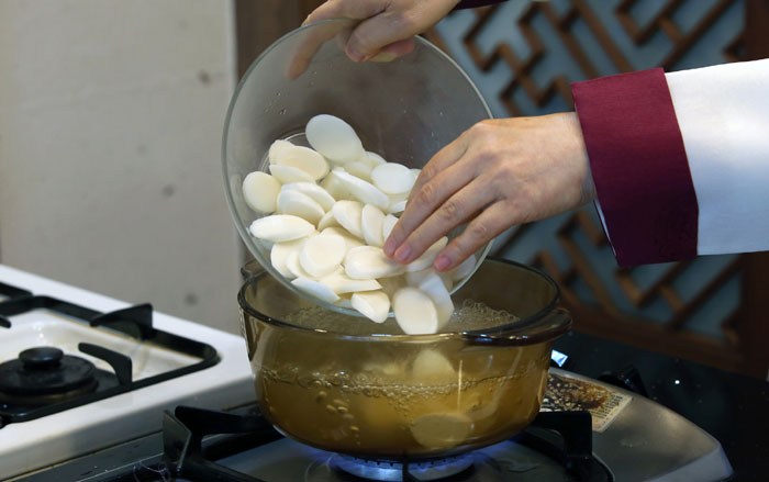 Добавьте соевый соус, чтобы сделать суп вкуснее. Варите несколько минут, затем добавьте рисовые пирожки. Посолите. Чтобы приготовить бульон, вы можете также использовать коленную кость, грудинку или голень.