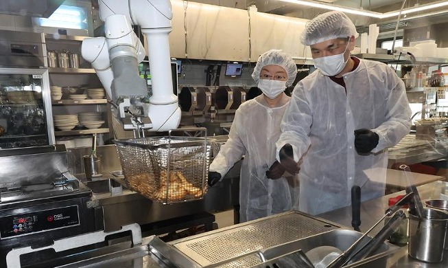 Министр О Ю Гён осматривает робота-повара в ресторане