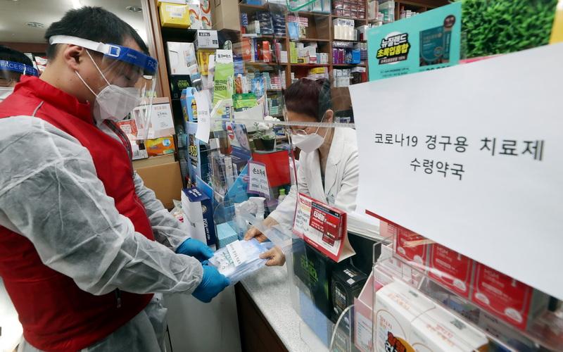 Лекарство от COVID-19 впервые поступит в Корею 13 января. На фото аптека в городе Инчхон (Пупхён-гу), где в рамках «Инструктажа по выдаче лекарств от COVID-19», представитель поликлиники Пупхён-гу передает лекарство фармацевту. / Фото: Рёнхап