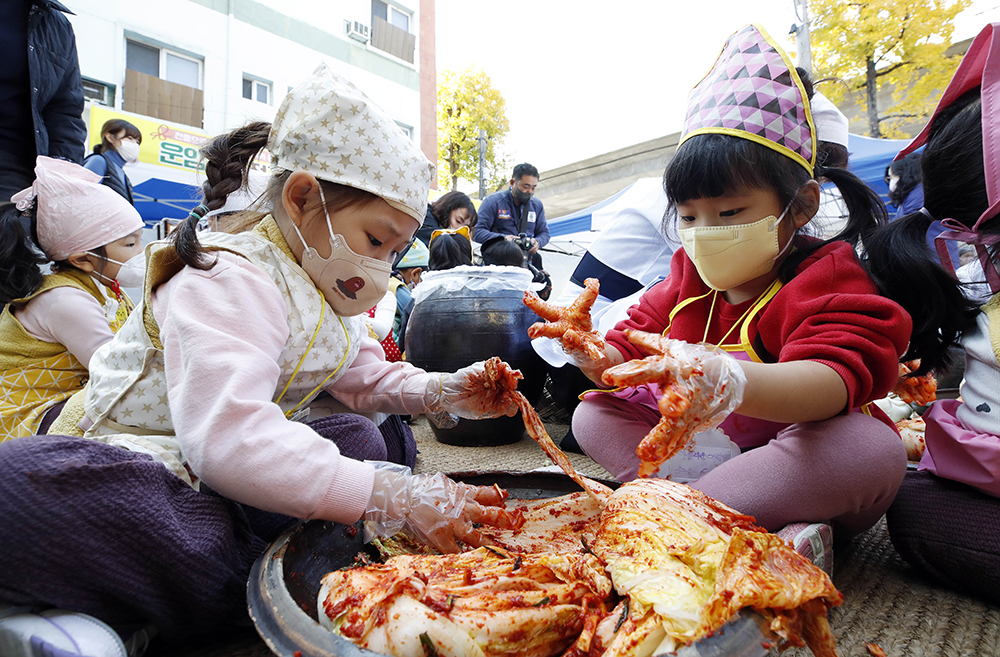 Утром 15 ноября дети помогают заготавливать кимчи на зиму в рамках волонтерской программы кимчжан (традиция приготовления и раздачи кимчи) в общественном центре Унам-2дон района Бук-гу в Кванджу.