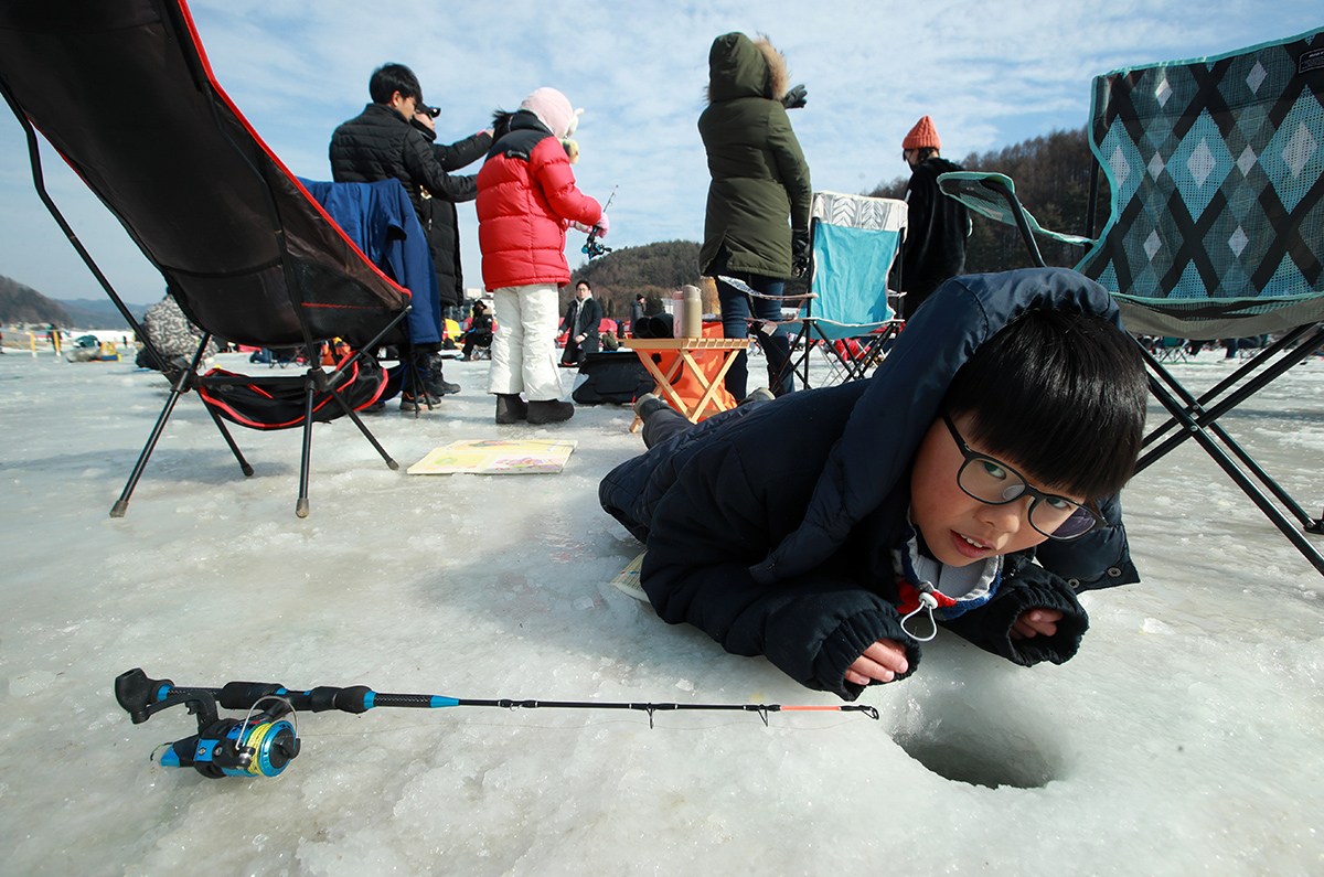 6 января мальчик ловит форель через прорубь во льду на ручье Одэчхон на Фестивале форели в Пхёнчхане, который проходит в поселке Чинбу-мён, уезд Пхёнчхан, провинция Канвондо. 