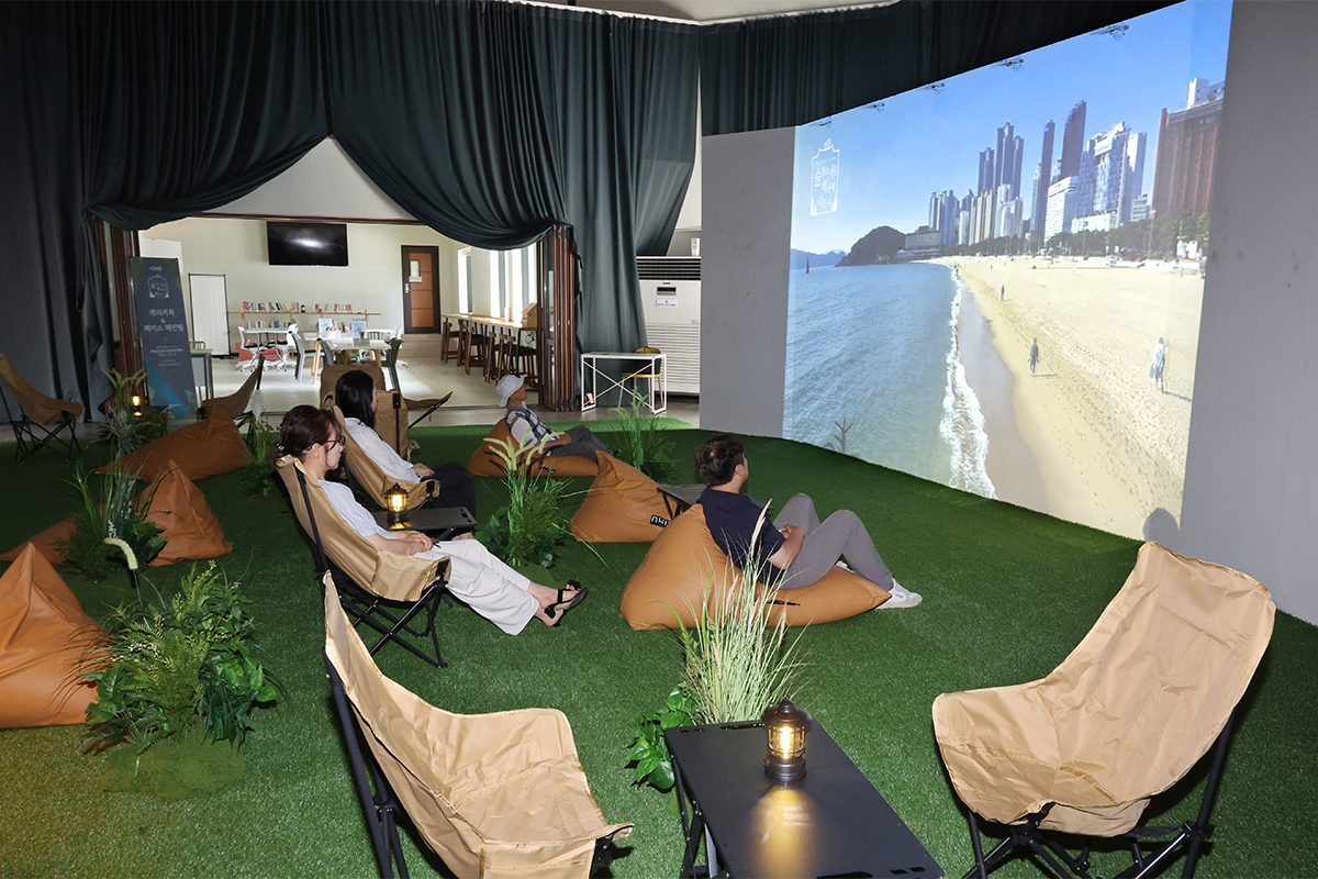 4 августа горожане и туристы, посетившие зону &laquo;Soopcance (Отдых в лесу) Haeundae Lounge&raquo;, открытую на Платформе Хэундэ в Пусане, отдыхают, расположившись на креслах-мешках и складных стульях. 